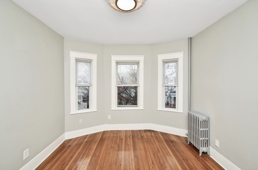 6 Coleman Street, Unit 2 Boston, MA 02125 - Photo 1 of 19 an empty room with wooden floor and windows