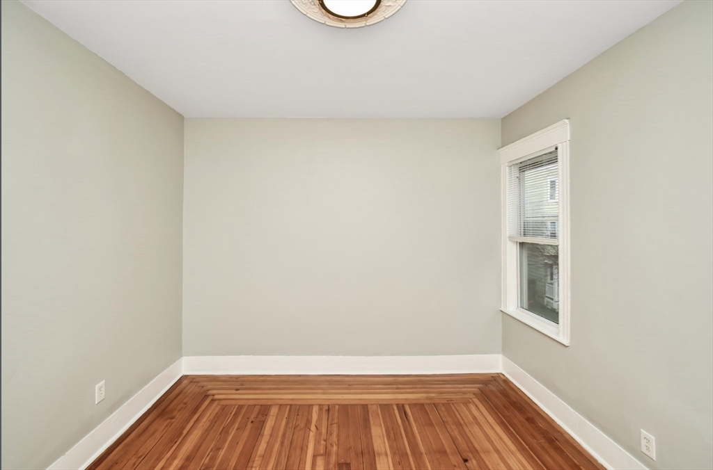 6 Coleman Street, Unit 2 Boston, MA 02125 - Photo 11 of 19 a view of an empty room with wooden floor and a window