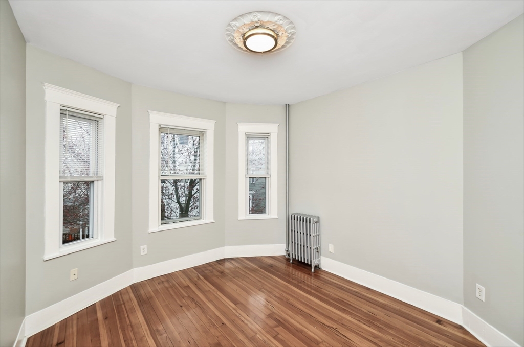 6 Coleman Street, Unit 2 Boston, MA 02125 - Photo 2 of 19 an empty room with wooden floor and windows