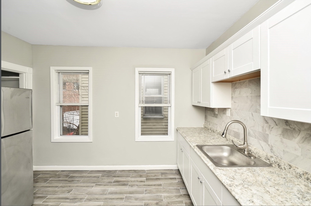 6 Coleman Street, Unit 2 Boston, MA 02125 - Photo 3 of 19 a kitchen with stainless steel appliances granite countertop a sink stove and refrigerator