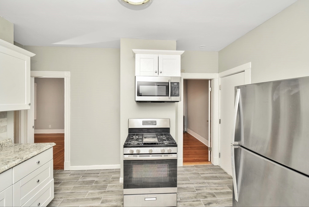 6 Coleman Street, Unit 2 Boston, MA 02125 - Photo 5 of 19 a kitchen with stainless steel appliances granite countertop a refrigerator stove and sink