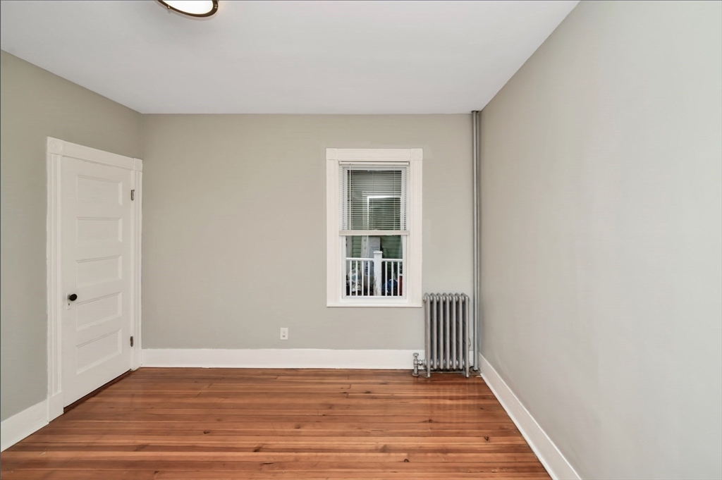 6 Coleman Street, Unit 2 Boston, MA 02125 - Photo 9 of 19 a view of an empty room with wooden floor and a window