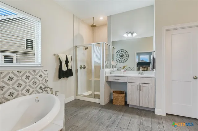 a bathroom with a bathtub sink and mirror