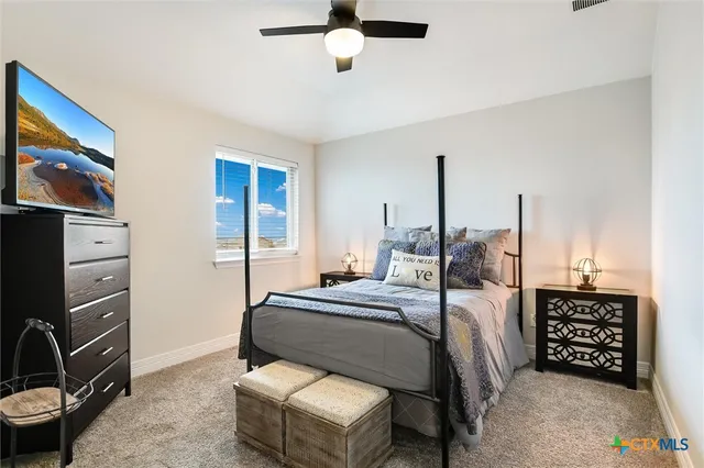 a bedroom with a bed a dresser and potted plants
