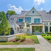 a front view of a house with a yard outdoor seating and mountain view