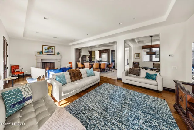 a view of a hallway with wooden floor and a bathroom