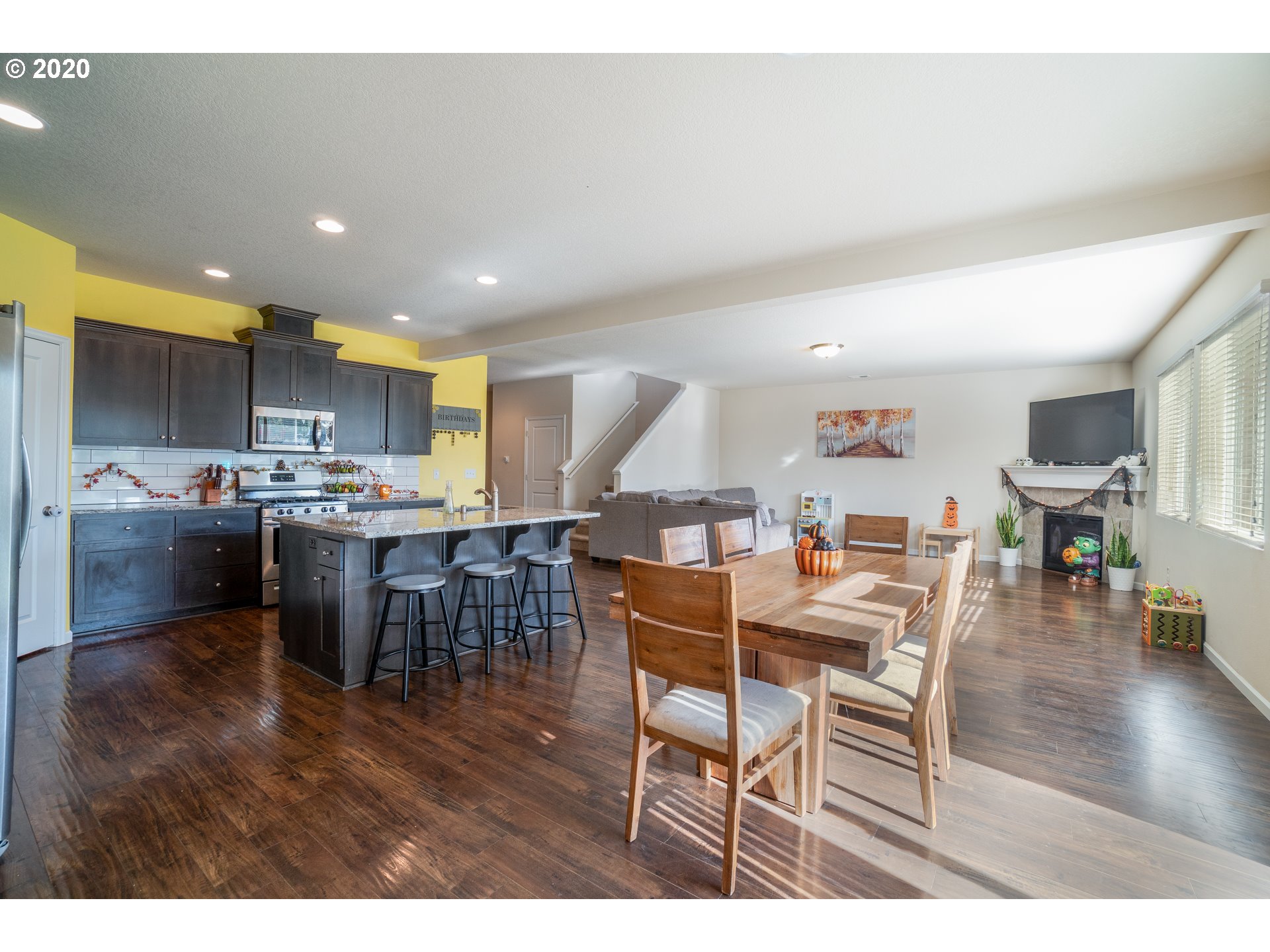 818 North Gibert Court Ridgefield, WA 98642 - Photo 10 of 30 a open kitchen with stainless steel appliances kitchen island granite countertop a dining table chairs and a refrigerator