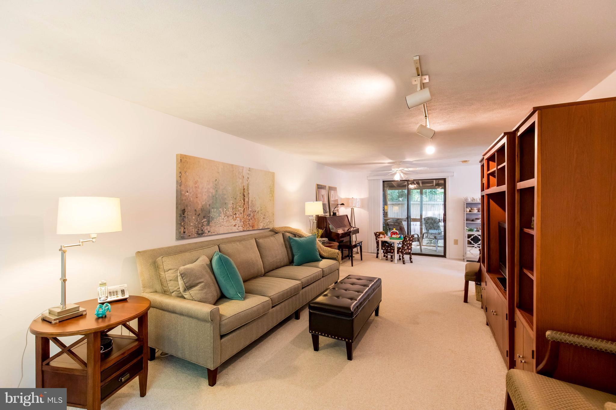 12255 Turkey Wing Court Reston, VA 20191 - Photo 4 of 30 a living room with furniture a lamp and a flat screen tv