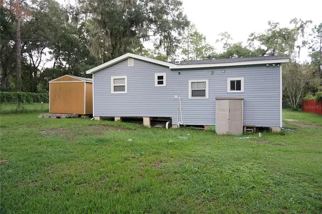 a view of a backyard with barn and large trees