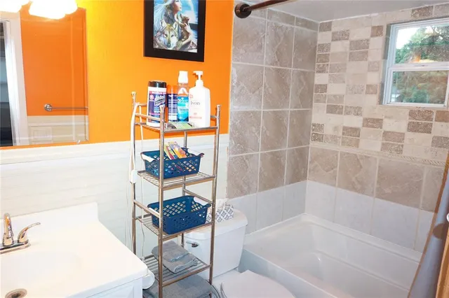 a bathroom with a toilet a sink and a mirror