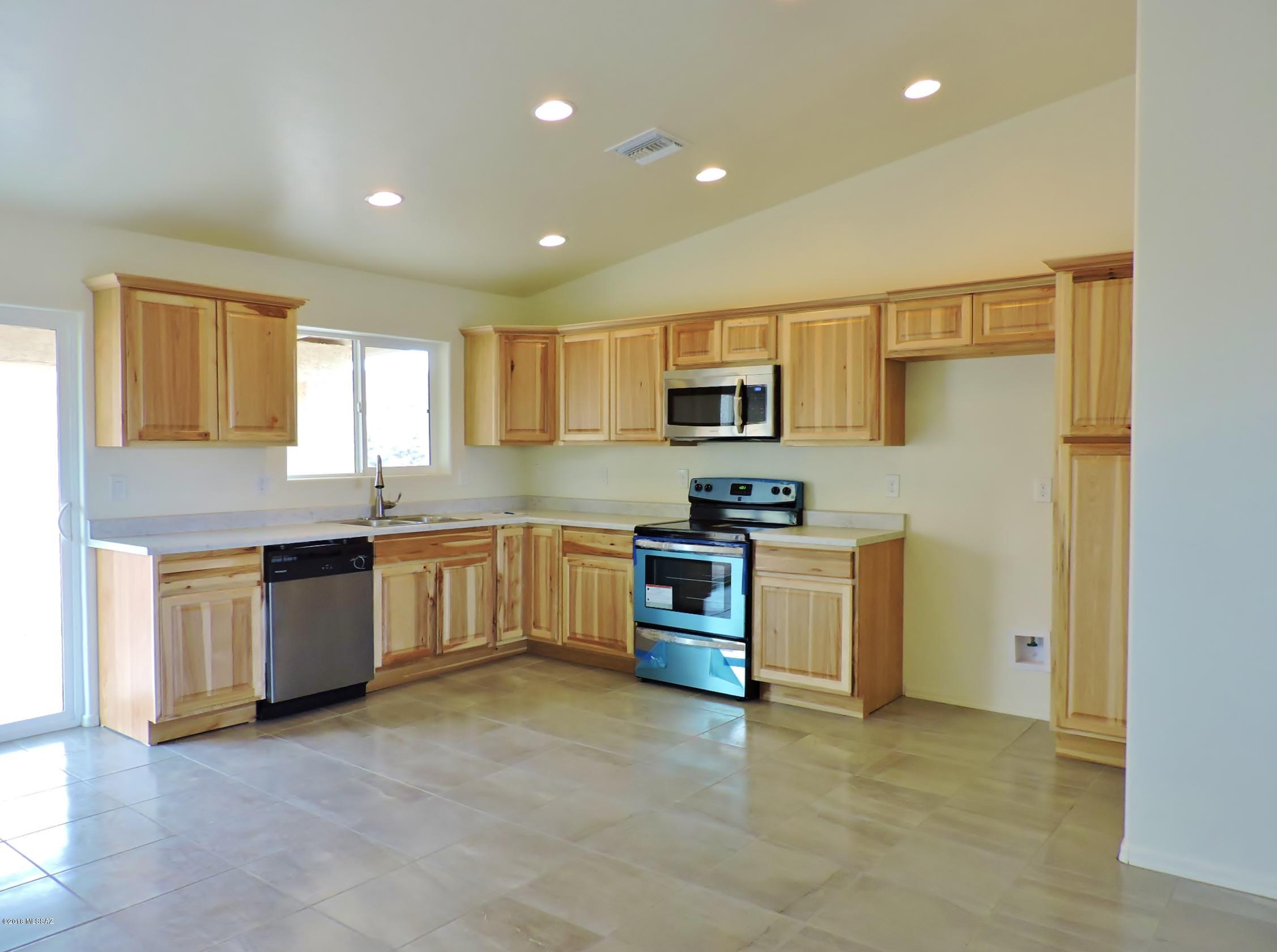 1604 Tigre Court Rio Rico, AZ 85648 - Photo 5 of 17 a kitchen with a stove a sink and a refrigerator