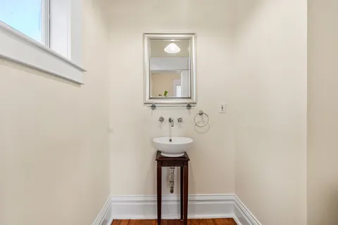 a kitchen with stainless steel appliances granite countertop a stove top oven a sink a dining table and chairs with wooden floor