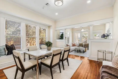 a view of a dining room with furniture a chandelier and wooden floor