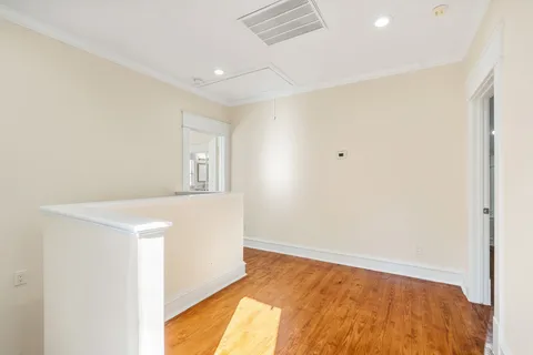 a kitchen with stainless steel appliances granite countertop a refrigerator a sink dishwasher a stove and white cabinets with wooden floor