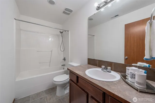 a bathroom with a granite countertop sink toilet a mirror and shower