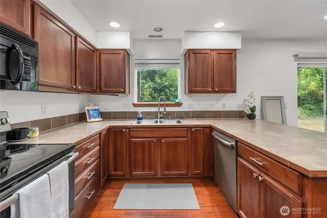 a kitchen with stainless steel appliances granite countertop a sink stove and cabinets
