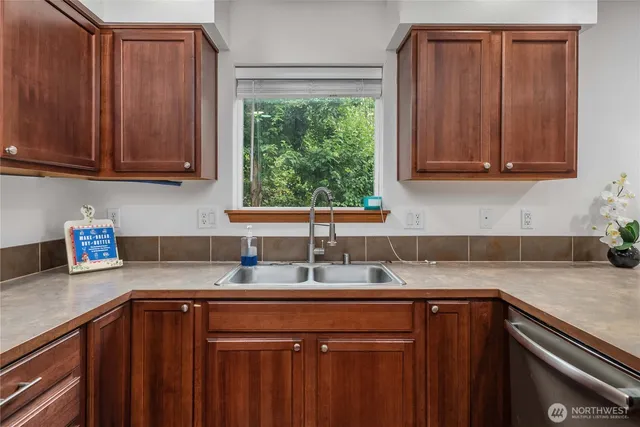 a kitchen with granite countertop wooden cabinets a sink and a window