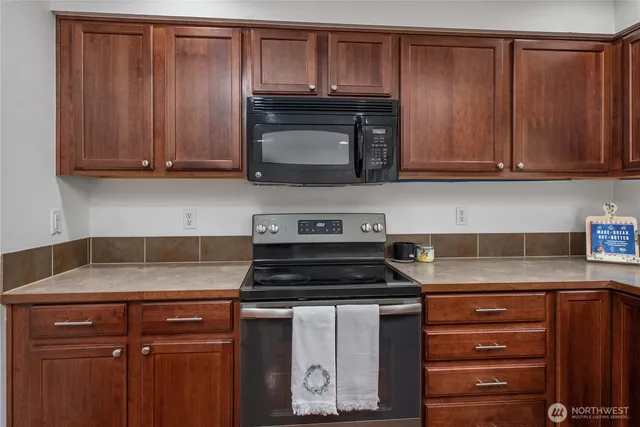 a kitchen with granite countertop wood cabinets and a stove top oven