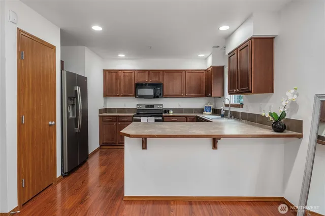 a kitchen with stainless steel appliances granite countertop a stove a sink a refrigerator and a microwave