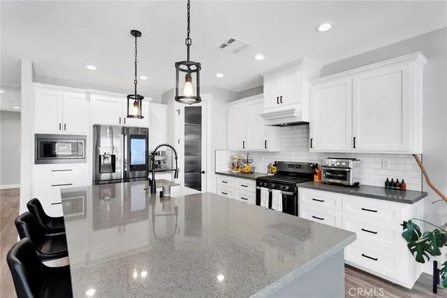 a kitchen with stainless steel appliances granite countertop a sink a stove and cabinets