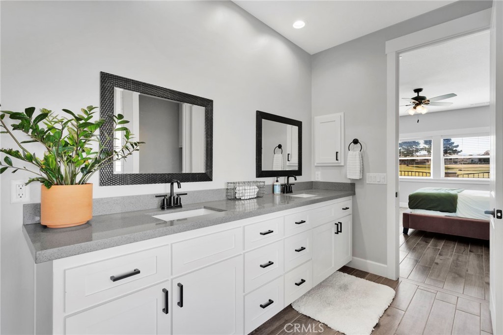 12634 Spring Valley Parkway Victorville, CA 92395 - Photo 26 of 42 a bathroom with a granite countertop sink a potted plant and a mirror