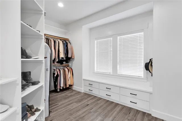 a view of walk in closet with clothes and shoes