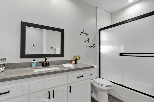 a bathroom with a granite countertop sink toilet and shower