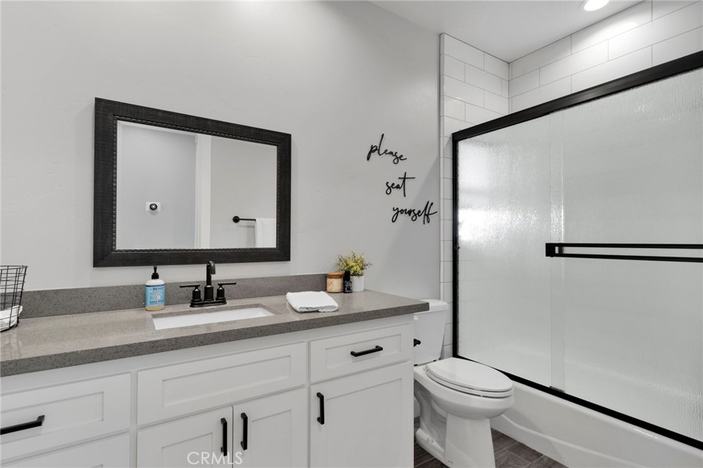 12634 Spring Valley Parkway Victorville, CA 92395 - Photo 28 of 42 a bathroom with a granite countertop sink toilet and shower
