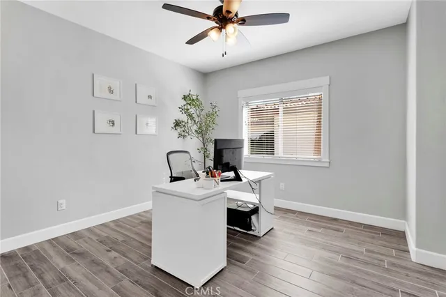 a view of a workspace with wooden floor and a window