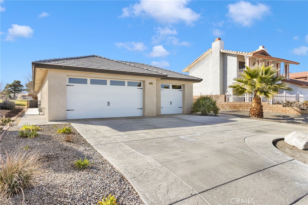 12634 Spring Valley Parkway Victorville, CA 92395 - Photo 4 of 42 a front view of a house with a yard and garage