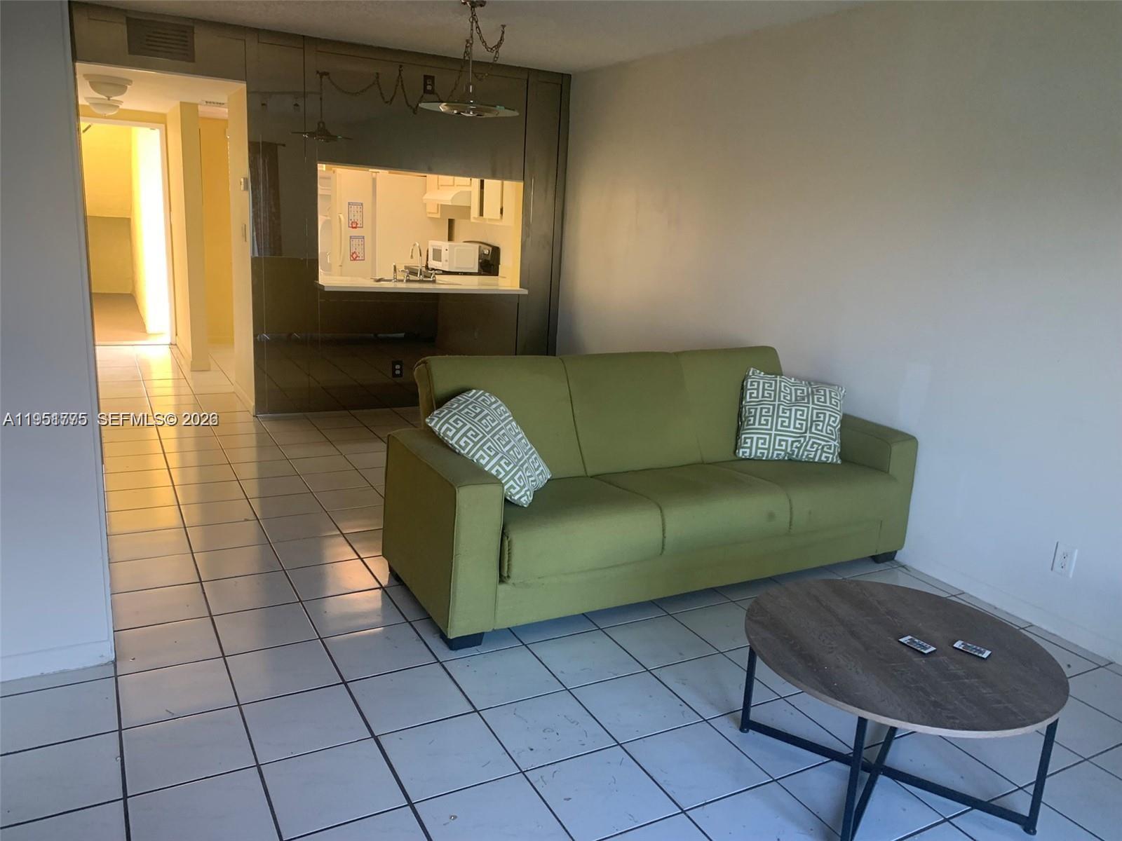 10009 Winding Lake Road, Unit 106 Sunrise, FL 33351 - Photo 3 of 7 a living room with furniture and a flat screen tv