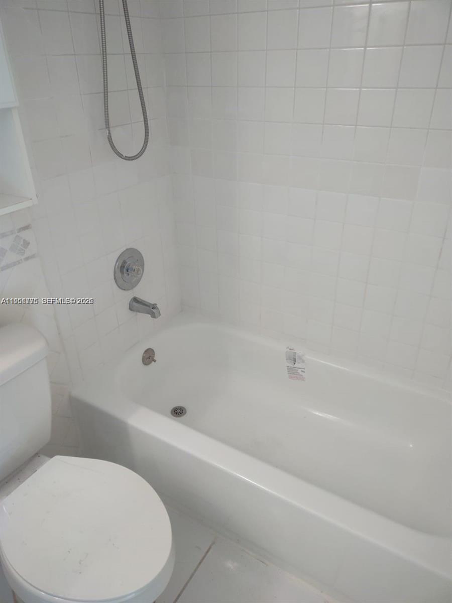 10009 Winding Lake Road, Unit 106 Sunrise, FL 33351 - Photo 5 of 7 a bathroom with a toilet and a bath tub