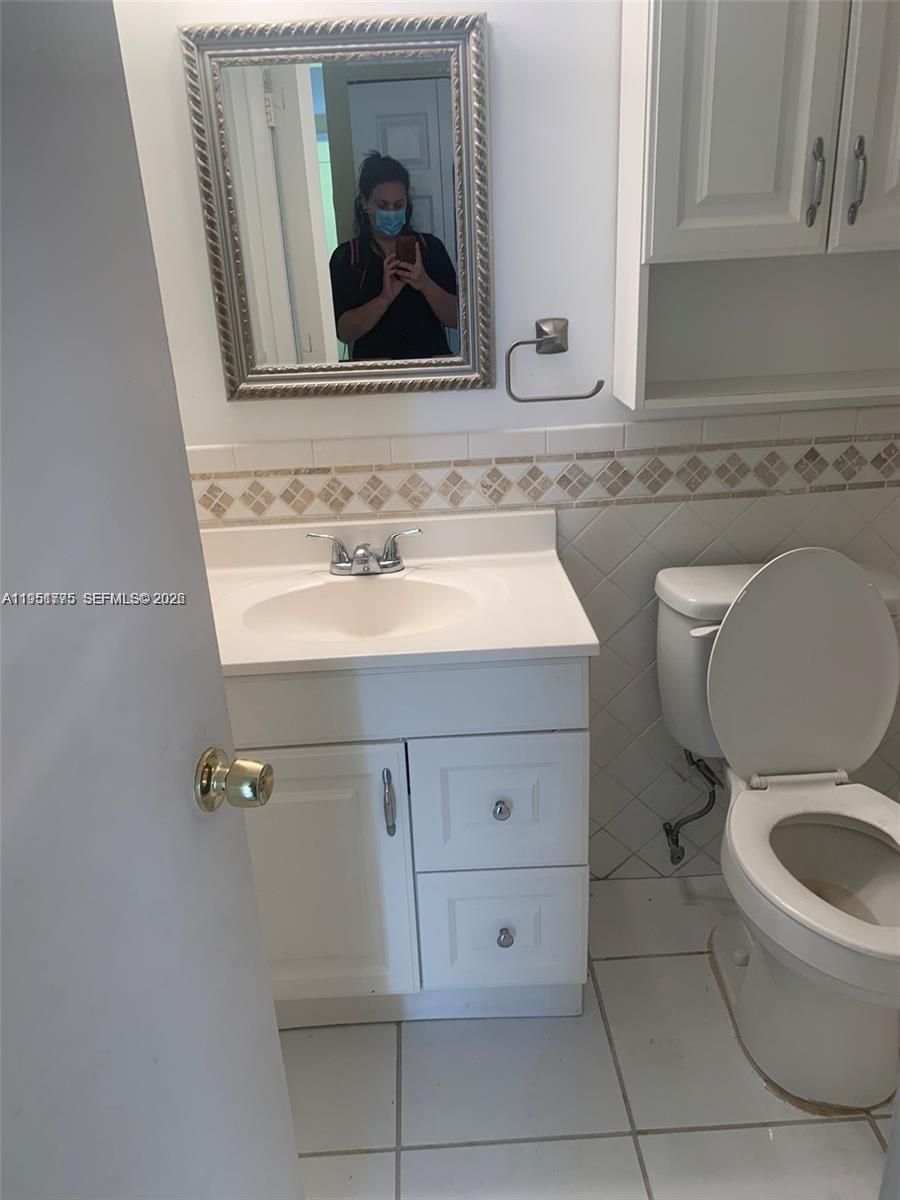 10009 Winding Lake Road, Unit 106 Sunrise, FL 33351 - Photo 6 of 7 a bathroom with a toilet sink and mirror