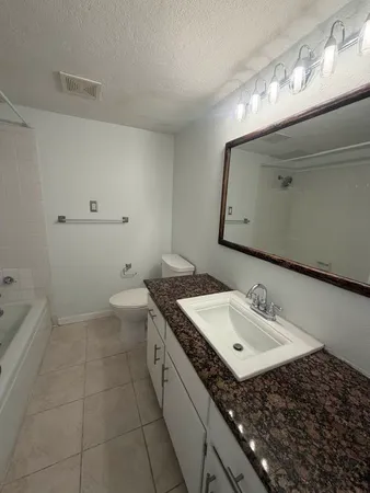 a bathroom with a sink toilet and mirror