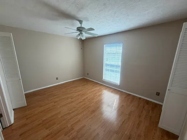 an empty room with wooden floor and windows