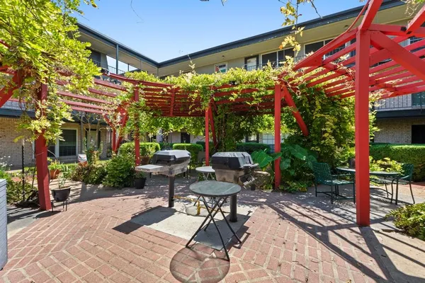 a view of a patio with a table and chairs and potted plants