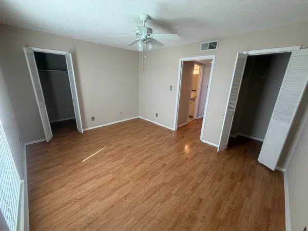 an empty room with wooden floor and closet
