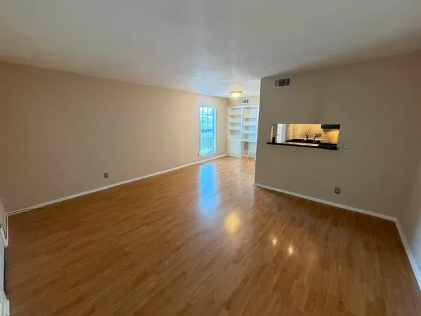 a view of empty room with wooden floor