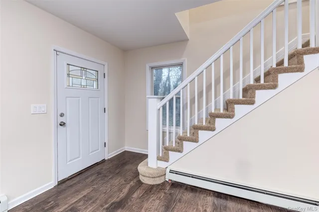 a view of staircase with wooden floor and white walls