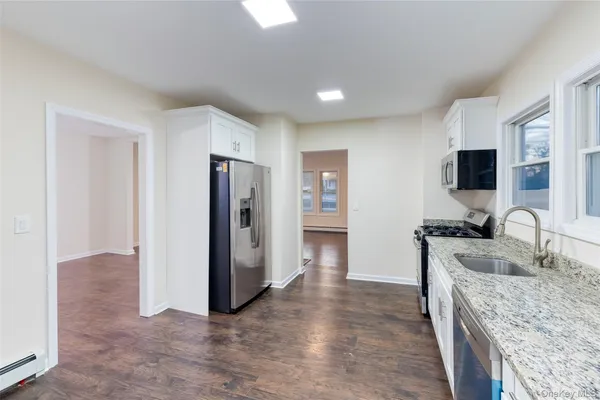 a kitchen with stainless steel appliances granite countertop a refrigerator stove and sink