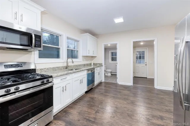 a large kitchen with stainless steel appliances granite countertop a stove and a sink