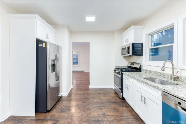 a view of a kitchen with stainless steel appliances granite countertop a refrigerator and a sink