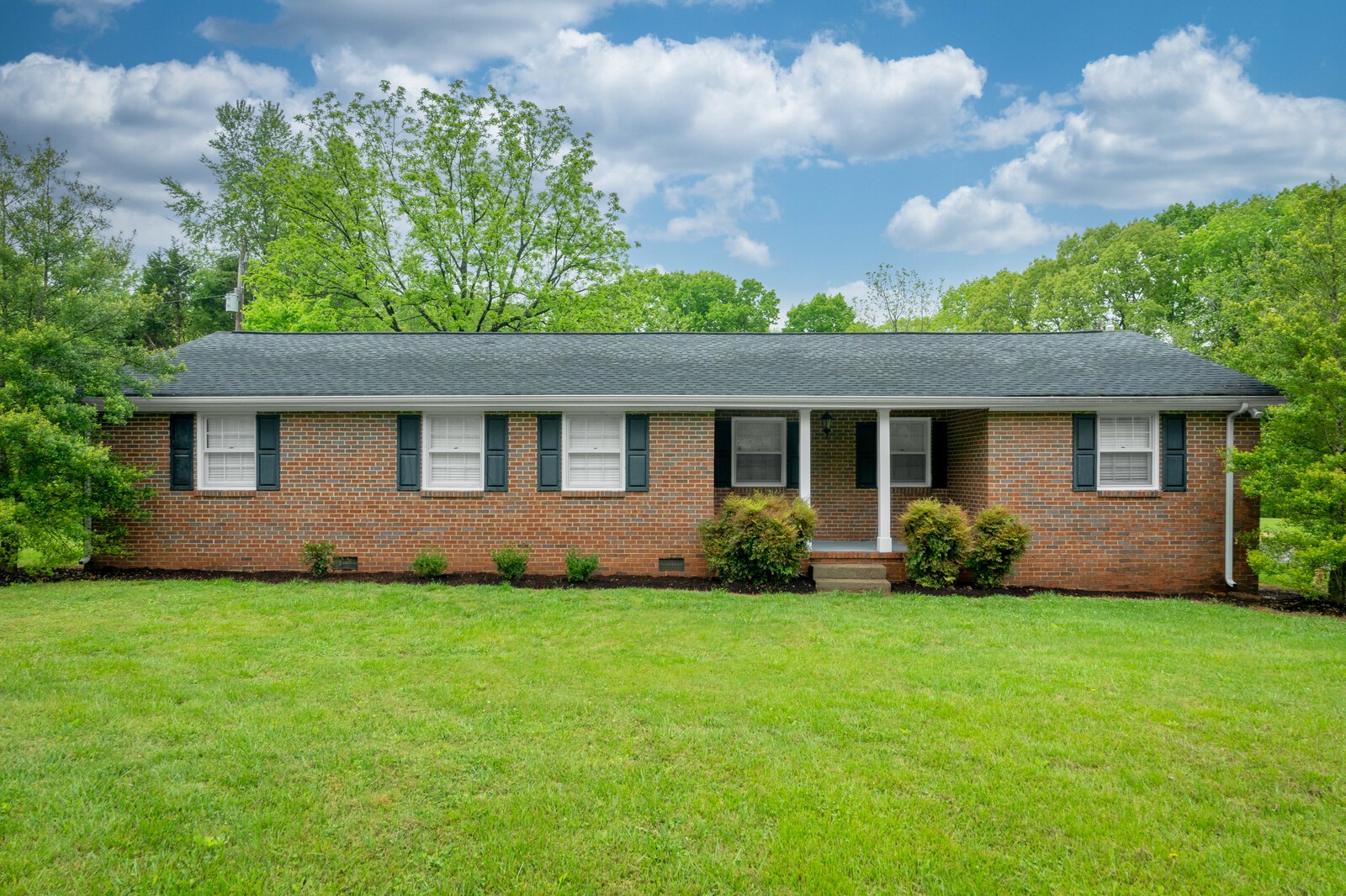 373 S Road Cottontown, TN 37048 - Photo 2 of 34 a front view of a house with a garden and yard