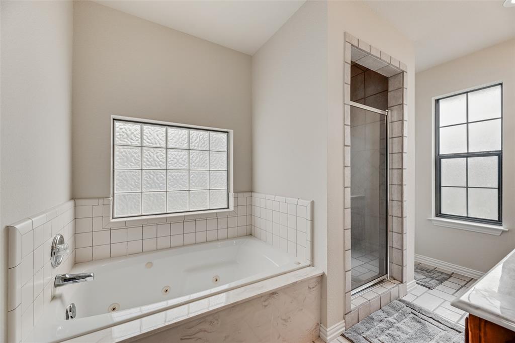 613 Torero Trail Oak Point, TX 75068 - Photo 12 of 32 a bathroom with a bathtub and a shower