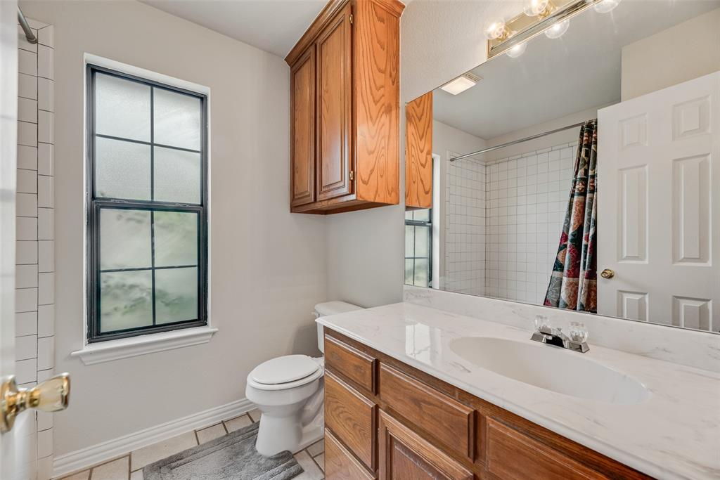 613 Torero Trail Oak Point, TX 75068 - Photo 15 of 32 a bathroom with a granite countertop sink toilet and mirror
