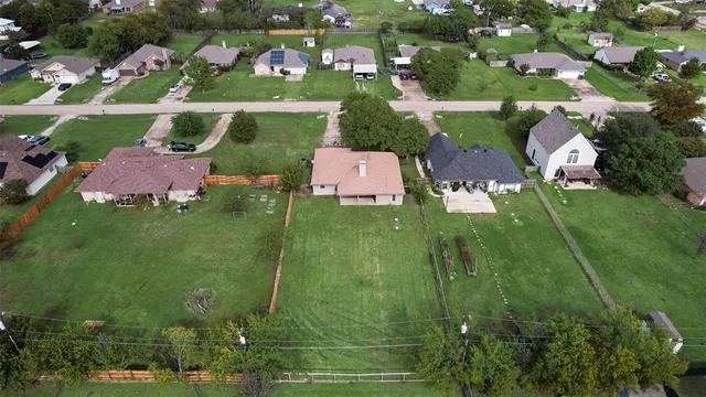 an aerial view of residential houses with outdoor space and trees