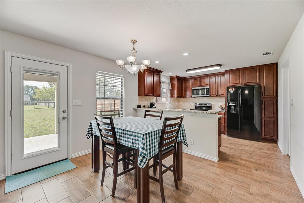 613 Torero Trail Oak Point, TX 75068 - Photo 6 of 32 a view of a dining room with furniture window and wooden floor