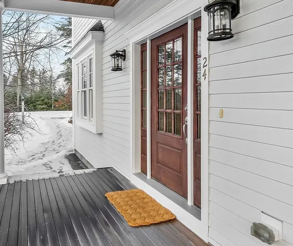 a view of a white house with a yard covered in snow