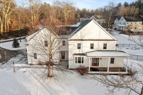 a view of a town with barn and large trees