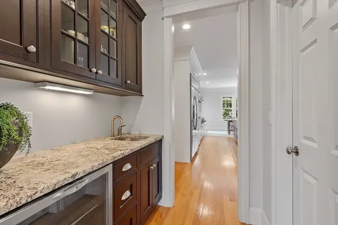 a kitchen with stainless steel appliances kitchen island granite countertop a sink a stove a refrigerator and island with wooden floor